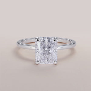 Close-up of a radiant hidden halo engagement ring in white gold, featuring an emerald-cut diamond. Available in 14K, 18K, or platinum.