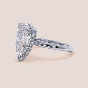 Elegant 14K white gold pear hidden halo solitaire engagement ring with a sleek plain band, perfect for timeless romance.  