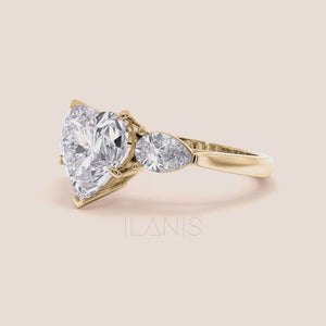 video of Unique yellow gold engagement ring featuring a heart-shaped central diamond flanked by teardrop side diamonds, exemplifying romantic elegance. 