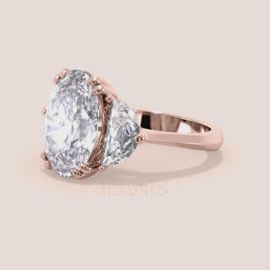 Close-up video of oval diamond three stone engagement ring in rose gold with pear side diamonds, showcasing sparkle, prong setting details and fine craftsmanship in motion 