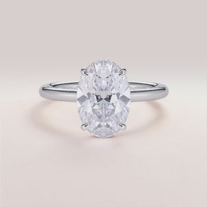 Elegant oval-cut diamond engagement ring in 14K/18K gold or platinum, featuring a sleek band and a hidden halo setting.