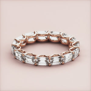 Elegant emerald-cut diamond eternity band in 14K rose gold, featuring sparkling diamonds.  Perfect for weddings and special occasions. 
