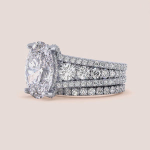 "14K white gold Hanie set featuring an oval hidden halo, accent prongs, and a stunning three-row band engagement ring.