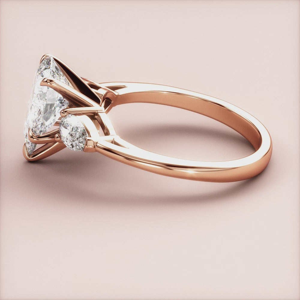 Elegant 14K rose gold engagement ring with a Marquise-cut diamond center and pear-shaped accents, beautifully crafted design.|







#14KRecycledRoseGold
#18KRecycledRoseGold


