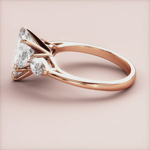 Elegant 14K rose gold engagement ring with a Marquise-cut diamond center and pear-shaped accents, beautifully crafted design.