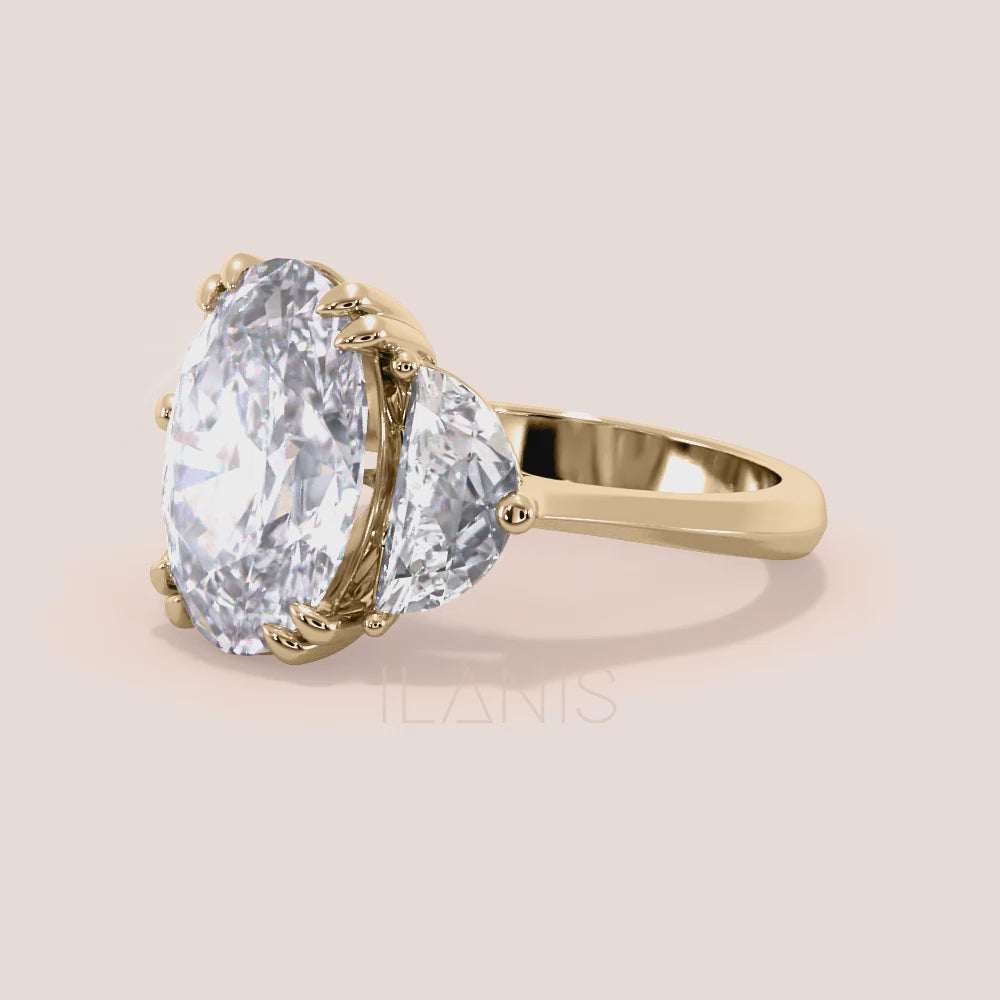 Close-up video of oval diamond three stone engagement ring in yellow gold with pear side diamonds, showcasing sparkle, prong setting details and fine craftsmanship in motion | #14KRecycledYellowGold #18KRecycledYellowGold