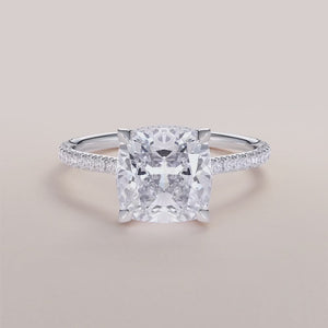 "White gold 18K cushion engagement ring with invisible gallery and hidden halo, featuring a stunning pave band design.