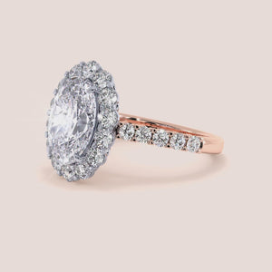 Two-tone 14K rose and white gold oval diamond ring with halo and pave band, perfect for engagement or weddings. 