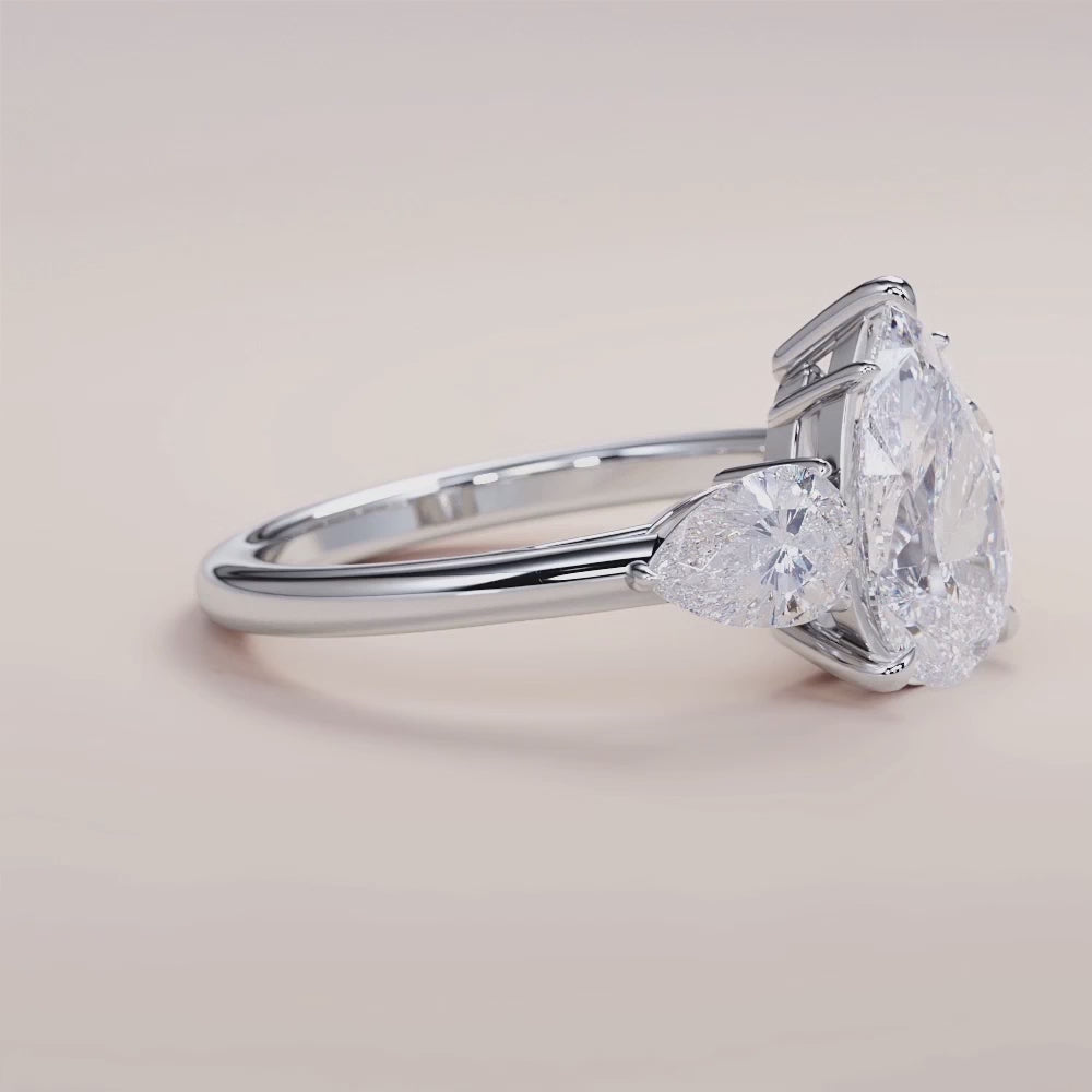 "14K white gold Romy pear three-stone engagement ring with side stones, perfect for a timeless and elegant proposal.|

#14KRecycledWhiteGold
#18KRecycledWhiteGold








#Platinum"
