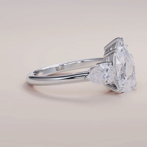 "14K white gold Romy pear three-stone engagement ring with side stones, perfect for a timeless and elegant proposal.