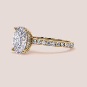 Elegant oval diamond engagement ring in 14K gold, featuring a sparkling diamond band and a prominent solitaire setting.
