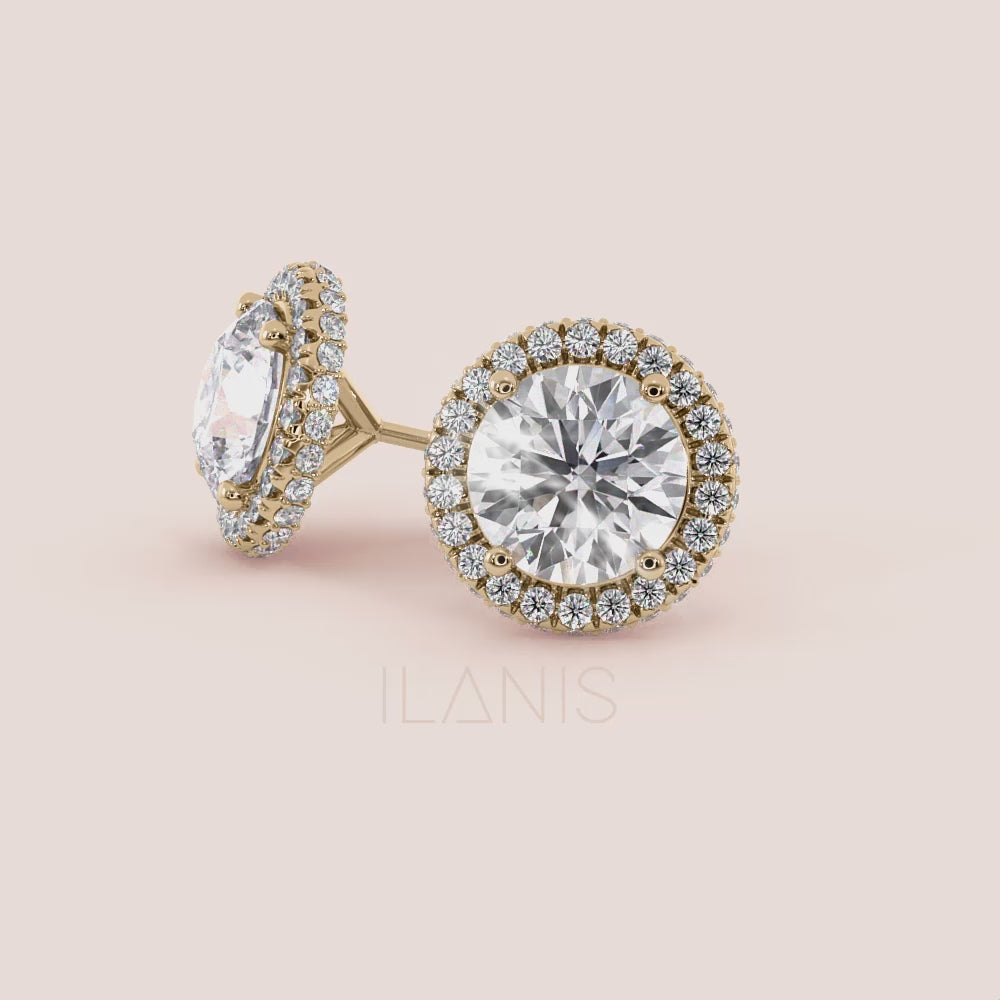 Close-up video of signature round halo diamond stud earrings in yellow gold, capturing light reflection, halo sparkle and fine setting details in motion | #14KRecycledYellowGold #18KRecycledYellowGold