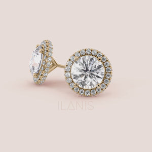 Close-up video of signature round halo diamond stud earrings in yellow gold, capturing light reflection, halo sparkle and fine setting details in motion 