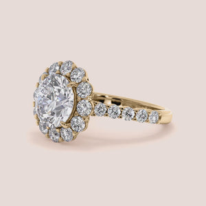 Elegant ring with a round diamond surrounded by a halo of smaller diamonds, available in 14K or 18K gold or platinum.
