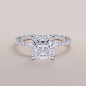 Cushion-cut diamond engagement ring with pave band in 14K or 18K white gold, perfect for a timeless proposal.