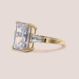 Elegant three-stone emerald-cut diamond ring in 14K/18K yellow gold, featuring tapered baguettes. Note: Jewelry is not worn on a model.