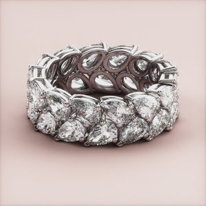 Luxury pear-shaped diamond eternity ring in 14K or 18K white gold, featured in a close-up shot for wedding band selection. 