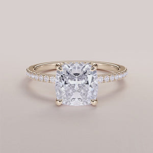 Elegant 14K gold cushion-cut diamond ring with a diamond-studded band on a neutral background. Perfect for engagement.