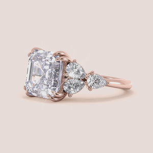 """Elegant 14K Rose Gold engagement ring with asscher and pear cut diamonds, featuring side stones for a dazzling shine.""