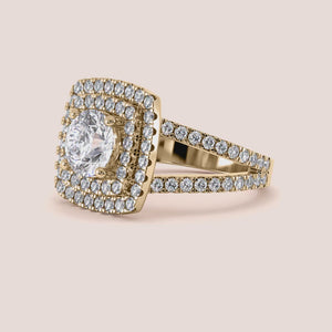Gold ring with a radiant cushion-cut diamond and double halo, encrusted with diamonds in 14K or 18K gold or platinum.
