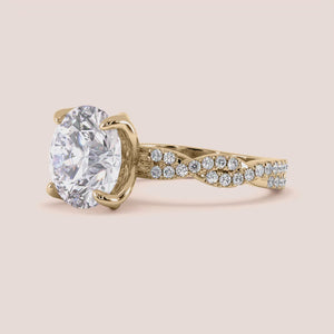 Radiant-cut diamond engagement ring with side stone accents in 14K yellow gold, displayed on a neutral background.