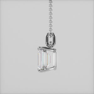 A close-up of a solitaire emerald-cut diamond pendant in a four-prong white gold setting. This elegant and modern design enhances the diamond’s brilliance while maintaining a minimalist aesthetic.
