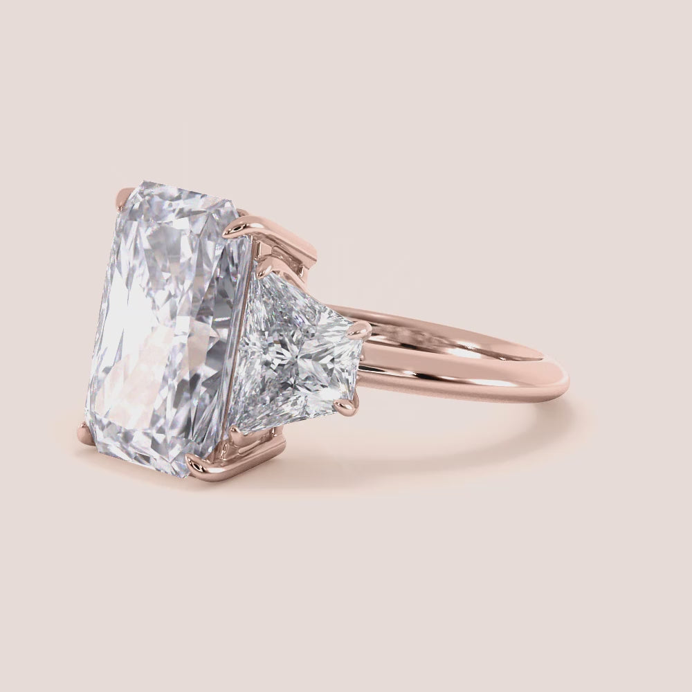 "Rose Gold 14K radiant three-stone trapezoid engagement ring, showcasing timeless elegance and brilliance. Perfect for proposals.|







#14KRecycledRoseGold
#18KRecycledRoseGold


"
