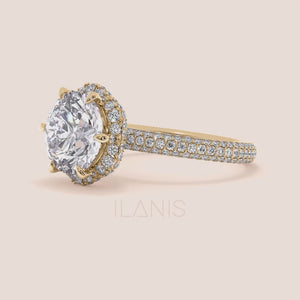 Video of Exquisite yellow gold engagement ring featuring a halo of pavé-set diamonds around a radiant cushion-cut center stone, mounted on a fully diamond-encrusted band. 