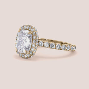 Radiant-cut diamond engagement ring with side stone accents in 14K yellow gold, displayed on a neutral background.