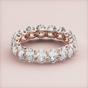Elegant 14K or 18K rose gold diamond eternity wedding band with round brilliant-cut diamonds in shared prong setting. 