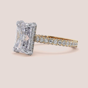 Two-tone 14K gold emerald-cut diamond ring with pav‚ setting, featuring a radiant hidden halo in white and yellow gold. 