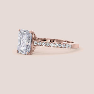 Elegant engagement ring with a radiant-cut diamond, set in a pave band, crafted from 14K or 18K rose gold or platinum.
