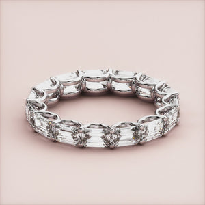 14K or 18K white gold eternity band featuring emerald-cut diamonds, elegantly displayed against a neutral background. 