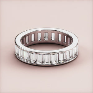 Elegant 14K or 18K white gold emerald-cut diamond eternity wedding band featuring a seamless row of elongated facets. 