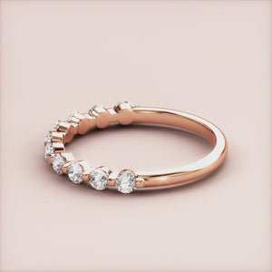 Elegant 14K rose gold half eternity wedding band with shared prong setting and dazzling round brilliant-cut diamonds. 