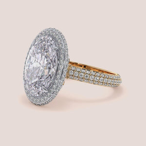 Two-tone 14K/18K white and yellow gold oval diamond ring with double edge halo, perfect for engagement. 
