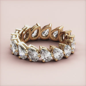 Exquisite 14K gold pear-shaped diamond eternity ring, perfect for weddings or special occasions, adorned with stunning diamonds. 
