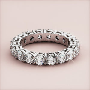 Elegant round-cut eternity wedding band in 14K or 18K gold or platinum, featuring a continuous row of sparkling diamonds. 