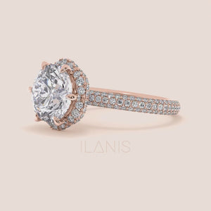 Video of Exquisite rose gold engagement ring featuring a halo of pavé-set diamonds around a radiant cushion-cut center stone, mounted on a fully diamond-encrusted band. 