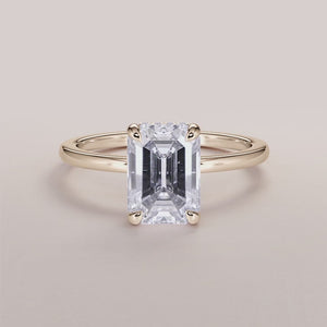 Elegant 14K yellow gold emerald hidden halo engagement ring with a classic plain band, not worn on model.