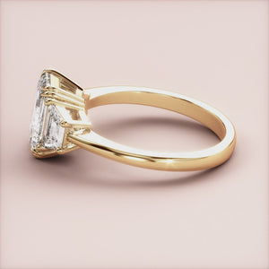 "14K Yellow Gold engagement ring featuring three emerald trapezoid stones, perfect for elegant proposals and timeless style.