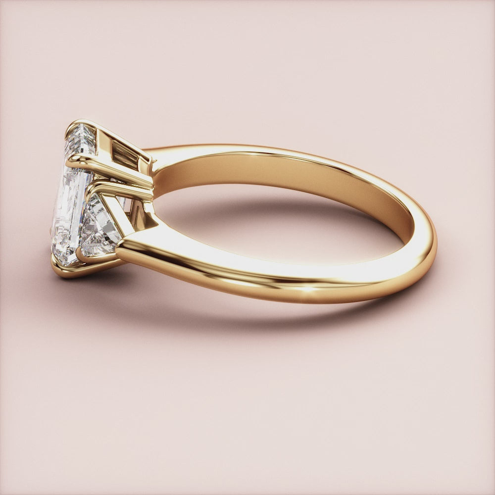 "14K yellow gold three-stone triangle engagement ring with emeralds, a stunning choice for an unforgettable proposal.|




#14KRecycledYellowGold
#18KRecycledYellowGold





"
