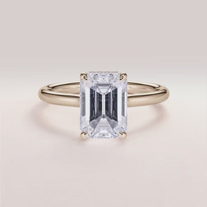 Elegant emerald-cut diamond solitaire engagement ring in yellow gold, available in 14K, 18K, or platinum, featuring a hidden halo.
#14KRecycledYellowGold
#18KRecycledYellowGold