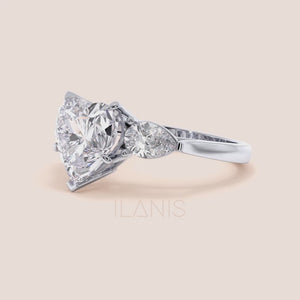 Video of Unique white gold engagement ring featuring a heart-shaped central diamond flanked by teardrop side diamonds, exemplifying romantic elegance. 