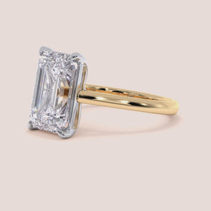 Emerald-cut two-tone 14K white and yellow gold diamond ring, featuring a stunning solitaire design in a cathedral setting. 