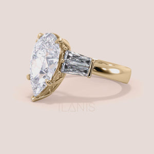 Pear shaped diamond engagement ring in yellow gold, rotating video featuring elegant three stone design with tapered baguette side diamonds and radiant center diamond 