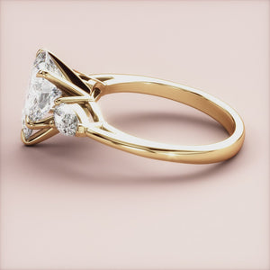 Luxurious 14K yellow gold engagement ring featuring a stunning pear-shaped diamond center stone and two smaller diamonds.