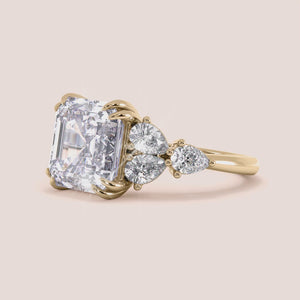 "14K Yellow Gold engagement ring featuring an asscher-cut center stone with pear cut side stones for a stunning, elegant look.
