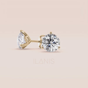 Luxurious 3-Prong Martini Diamond Earrings in yellow gold, isolated on beige background 