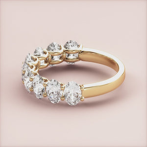 Elegant 14K or 18K yellow gold oval half eternity wedding band with round brilliant cut diamonds on a soft pink background. 